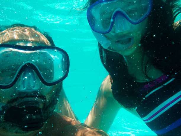 istock Father and daughter dipping into the pool. 903299432