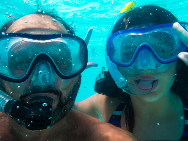 istock Father and daughter dipping into the pool. 903302320