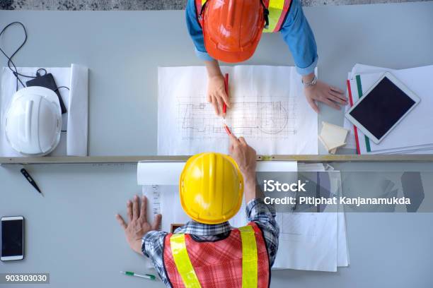 La Vista Dallalto Del Gruppo Di Ingegneri È La Riunione La Pianificazione Dei Lavori Di Costruzione Laspetto Dei Piani Cartacei In Cantiere La Vista Aerea - Fotografie stock e altre immagini di Industria edile