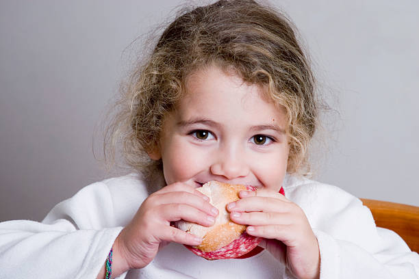 istock cute little girl eating a sandwich 90331030