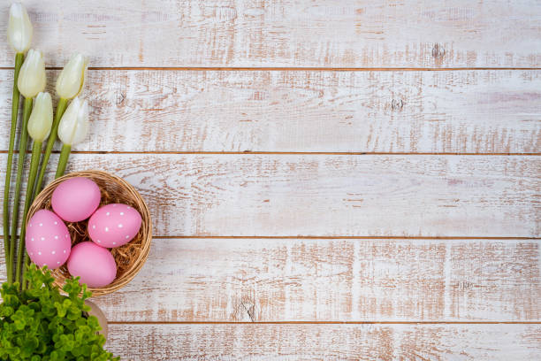 istock Colorful easter eggs and tulips over white wooden table 903317150