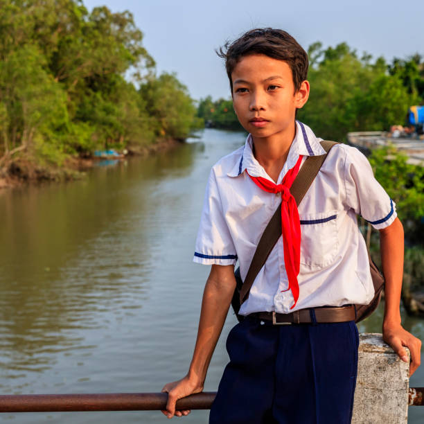 istock Vietnamese schoolboy sitting on a bridge, Mekong River Delta, Vietnam 903317676