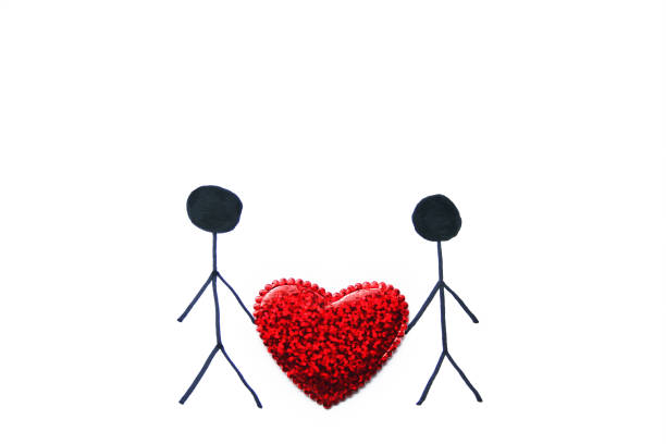 istock Two people drawing holding a shiny heart with copy space for your text or for graphic design.Top view.Concept for love and relationships,Saint Valentine's day ,marriage,wedding day party. 903322496