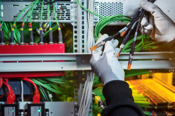 istock A worker in the server room connects the video cables to the server 903322780