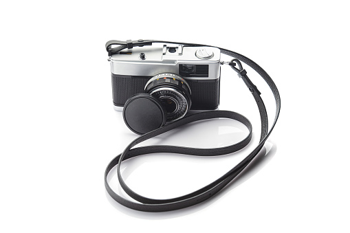 Vintage film camera with strap on white background