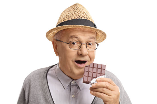 istock Mature man having a bite out of a chocolate bar 903323424