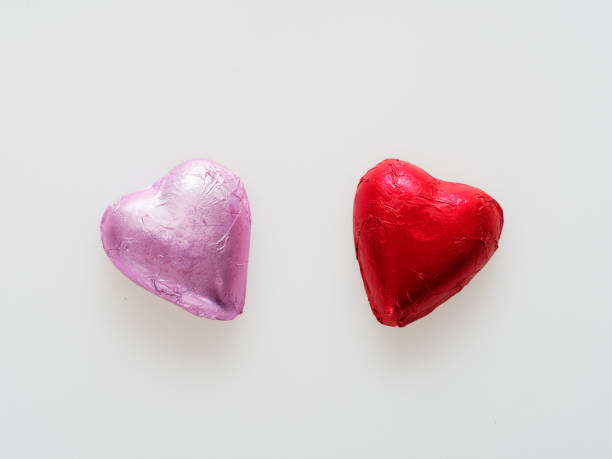 istock Heart shape chocolate wrapped in red and pink foil isolated over white background 903334990