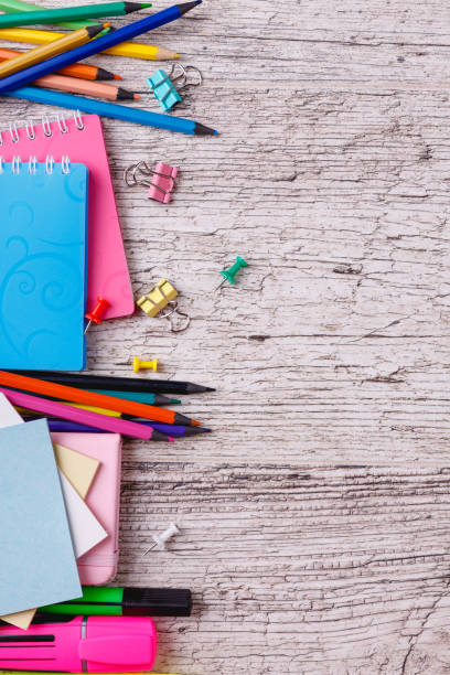 istock Notebooks and colored pencils on a wooden background with a place for writing. Top view. 903337608