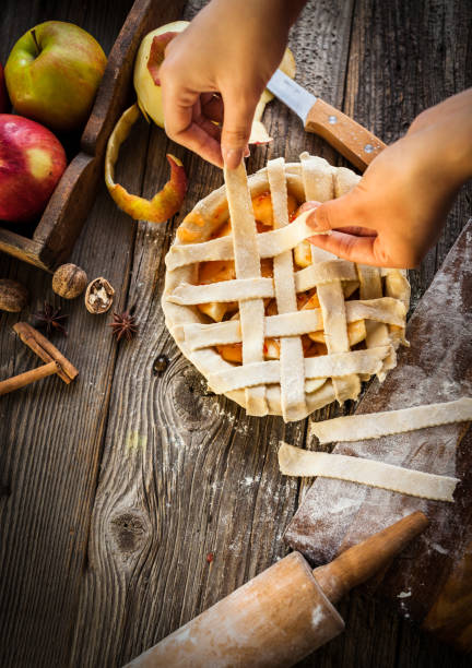Plate with apple pie in female hands on bright yellow background. Traditional dessert for Thanksgiving day. Copy space.