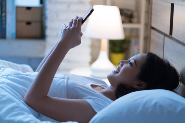 istock Asian women are using the smart phone on the bed before she sleeping at night. Mobile addict concept. 903342936