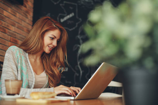 istock Young woman typing on laptop in cafe 903346578