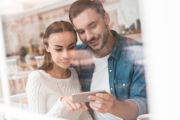 istock A guy and a girl are sitting together in a cafe. 903349314