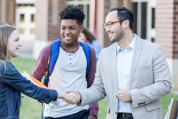 istock High school teacher meeting students outside on campus 903350846