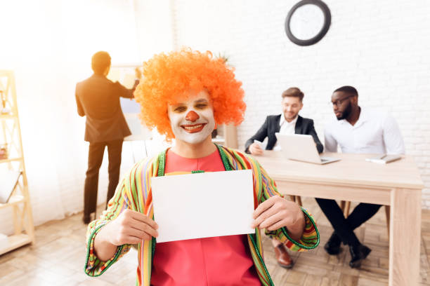 道化師のスーツとかつらの男性は、4 月 1 日営業所に座っています。 - clown laptop bizarre men ストックフォトと画像