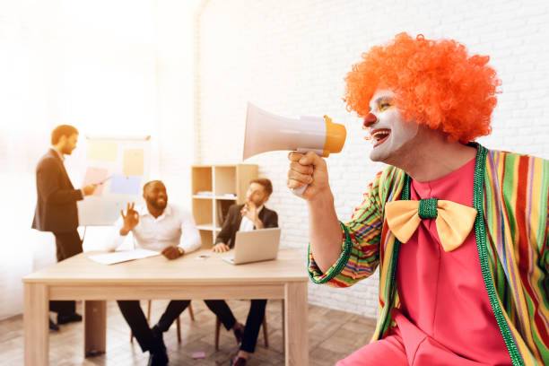 un uomo con un abito da clown parla in un altoparlante. - clown laptop bizarre men foto e immagini stock