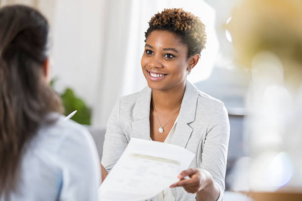 istock Confident businesswoman reviews document with client 903353748