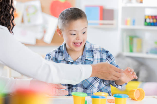 istock Little boy plays with playdough with teacher 903353808