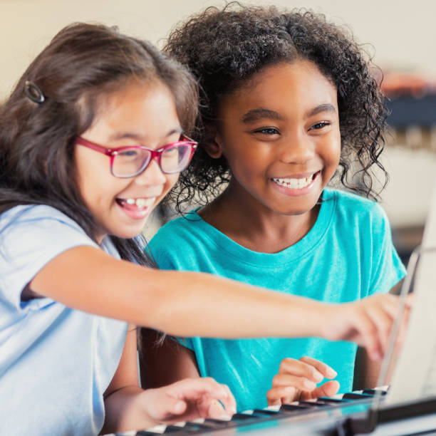 istock Two little girls enjoy practicing a piano duet together 903354092