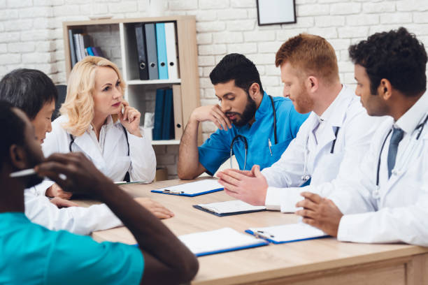 istock A group of doctors from different races is meeting at a table. 903354478