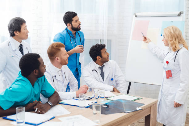istock A female doctor shows other doctors paper on a white board. 903354908