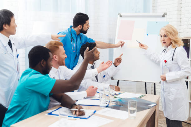 istock A female doctor shows other doctors paper on a white board. 903354920