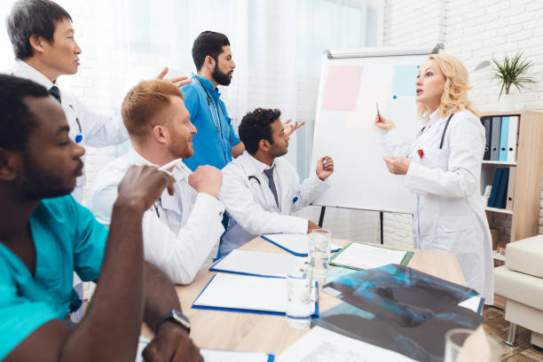 istock A female doctor shows other doctors paper on a white board. 903354936