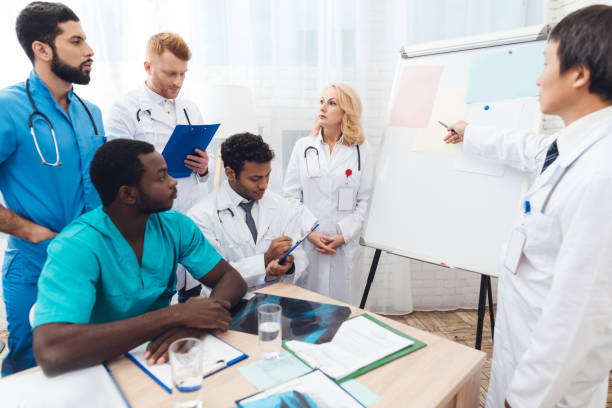 istock A doctor shows other doctors paper on a white board. 903354948