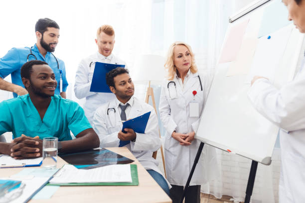 istock A doctor shows other doctors paper on a white board. 903354968