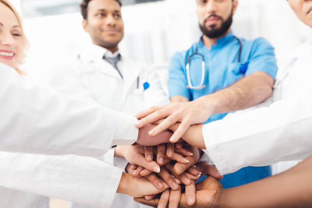 istock A group of doctors are holding each other's hands. 903357654