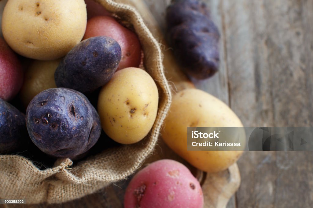 Raw potatoes close up Raw potatoes close up on a wooden table Raw Potato Stock Photo