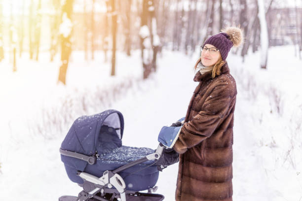 istock Woman walking with stroller in forest at winter. 903360818