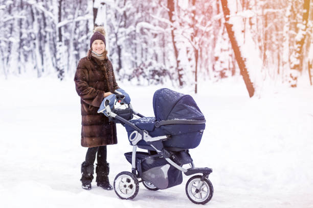 istock Woman walking with stroller in forest at winter. 903361318