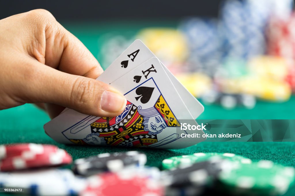 Gambling Hand Holding Poker Cards and Money Coins Chips Blackjack Stock Photo