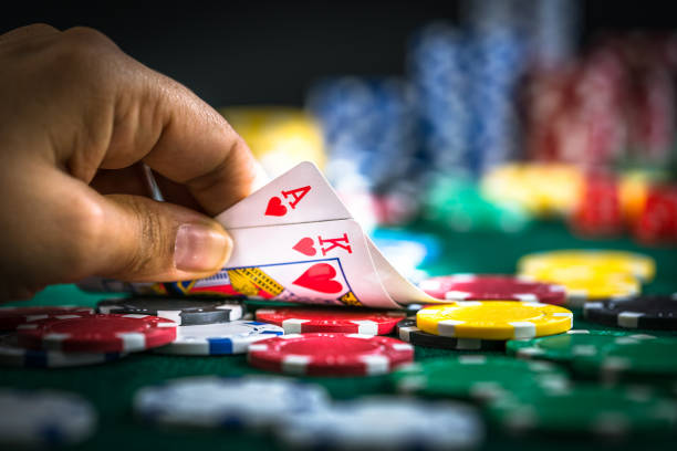 gioco d'azzardo mano tenendo carte da poker e monete di denaro chip - gambling foto e immagini stock