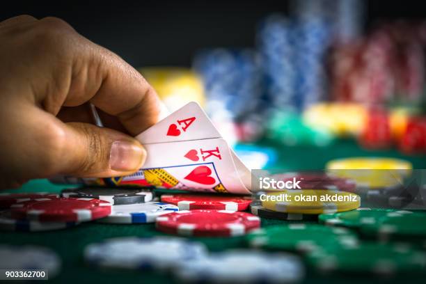 Gambling Hand Holding Poker Cards And Money Coins Chips Stock Photo - Download Image Now