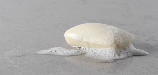 大理石プレート上の泡と白石鹸 - bar of soap ストックフォトと画像