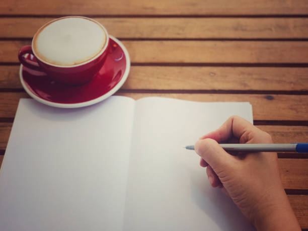 istock Hand writing on white paper with hot coffee in red cup on wooden table 903370464