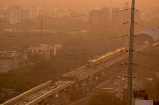 вечерний снимок поезда метро в туманный день дели - pollution street city street fog стоковые фото и изображения