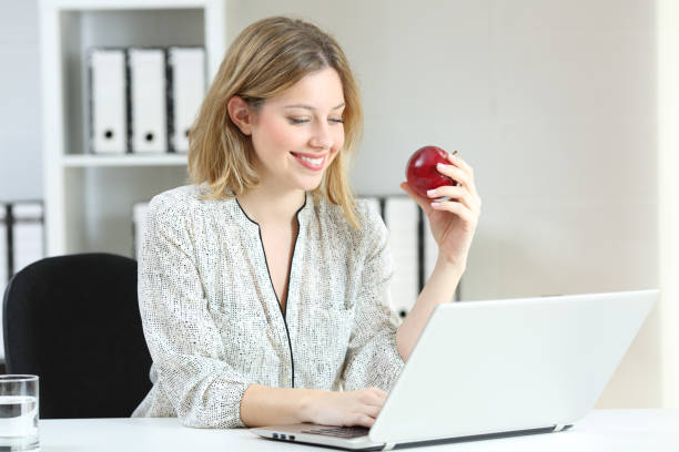 istock Businesswoman working holding an apple at office 903374950