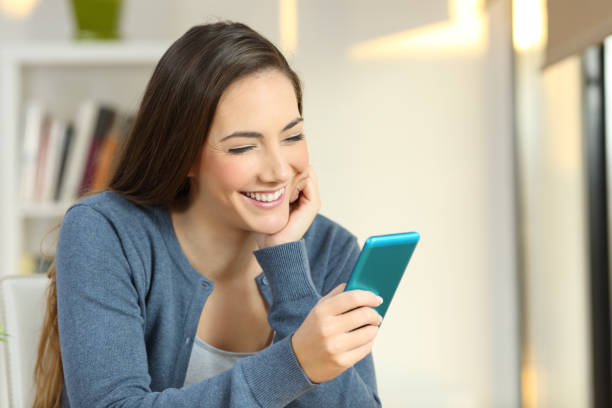 istock Happy woman reading text in a smartphone at home 903375698
