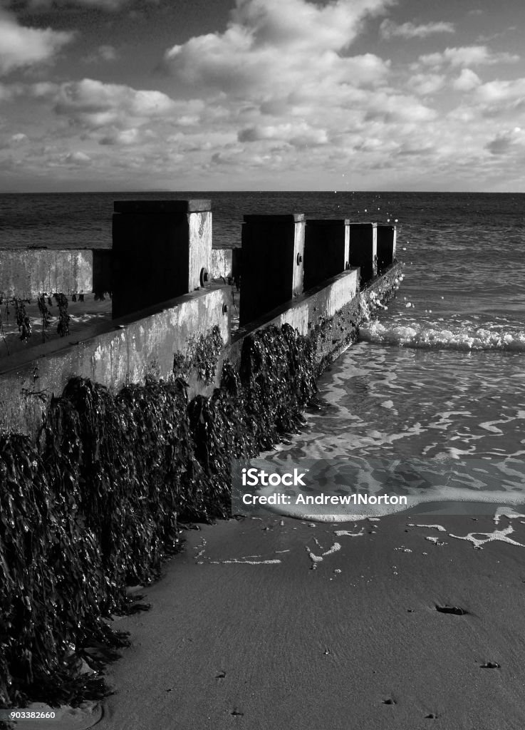 Breakwaters beach defences Swanage bay in Kent England, wave breaking against the breakwater sea defences Abstract Stock Photo