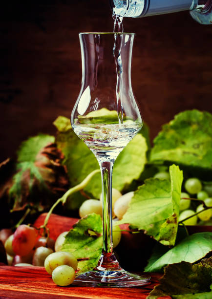 grappa lub wódka z winogron wylana do kieliszka - grappa photography food and drink vertical zdjęcia i obrazy z banku zdjęć