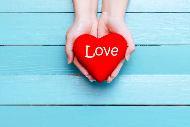 istock red heart in hands on a blue background 903386042