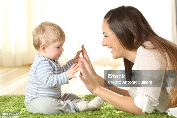 Photo libre de droit de Mère Jouant Avec Son Bébé Sur Un Tapis banque d'images et plus d'images libres de droit de Bébé - Bébé, Assistante maternelle, Garde d'enfant