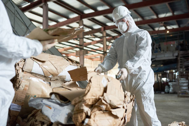 istock Worker in Protective Suit Sorting Cardboard at Factory 903412626