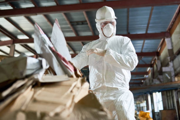 istock Worker in Hazmat Suit Sorting Cardboard at Recycling Plant 903412630