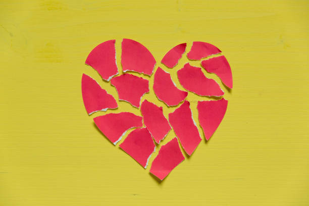 istock Crushed paper heart on yellow background. Broken heart concept 903413112
