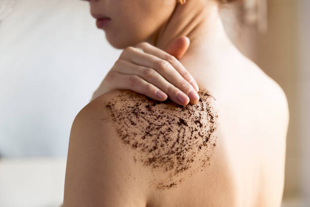 beauté, spa et le concept de santé de la peau - femme nettoie la peau du corps avec gommage café dans la salle de bain. - exfoliation photos et images de collection