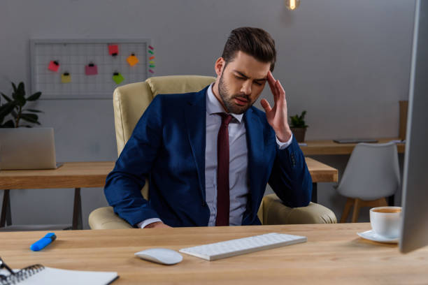 istock handsome businessman having headache at working place 903413580