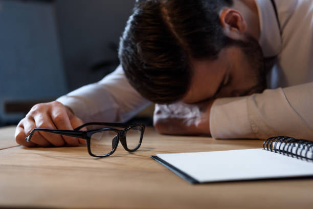 istock cropped image of tired businessman sleeping at working table 903416424